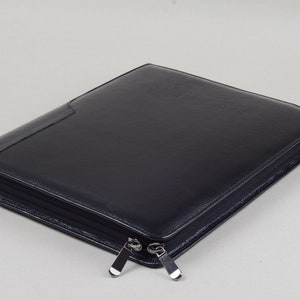 May include: A black leather zippered portfolio with two silver zippers.