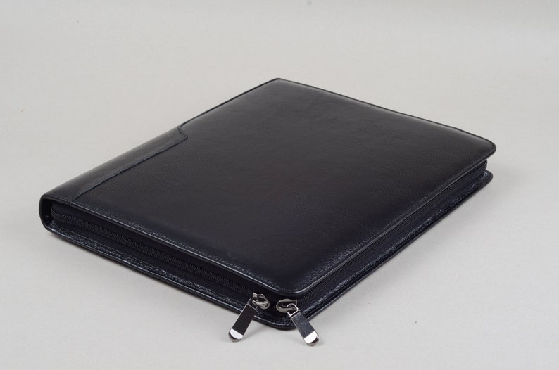 May include: A black leather zippered portfolio with two silver zippers.
