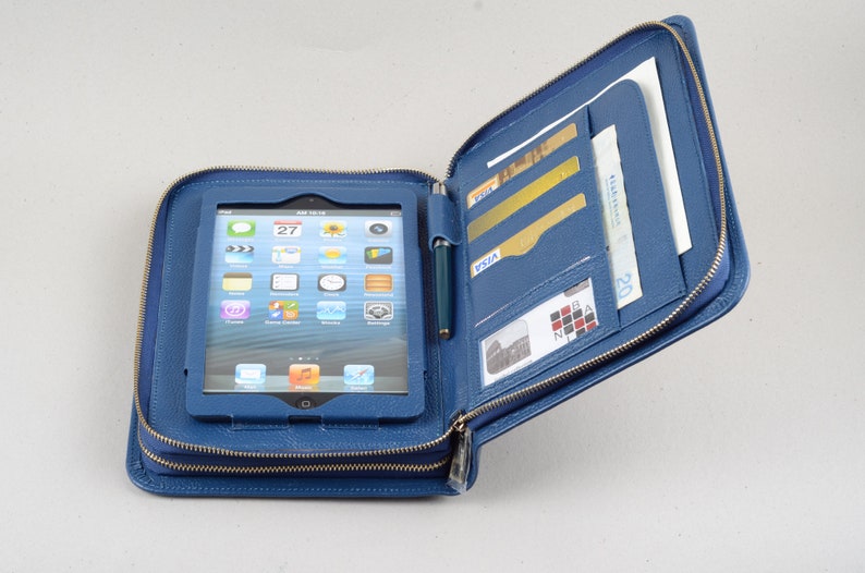 May include: A blue leather zippered case with a tablet computer inside. The case has multiple pockets and slots for cards, cash, and a pen.