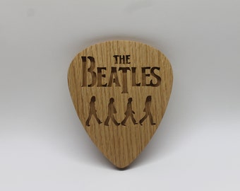 Beatles crossing Abbey Road on giant guitar pick shape, choice of oak or cherry. Decoration only, cannot be used as an actual guitar pick