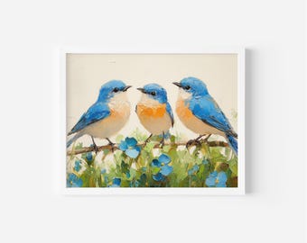 May include: A framed art print depicting three bluebirds on a branch with blue flowers and green leaves. The birds have blue plumage, orange breasts, and white underbellies. The artwork is set against a cream-coloured background.