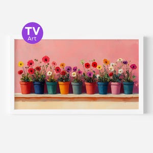 Puede incluir: Una obra de arte enmarcada que presenta una fila de flores en macetas sobre un fondo rosa. Las macetas son de varios colores, y las flores muestran una gama de tonos, incluyendo rojo, amarillo y morado. La obra de arte está etiquetada como "TV Art" en un círculo morado.