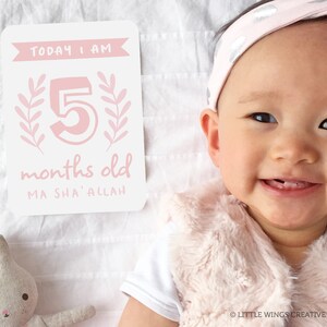 May include: A pink and white baby milestone card with the text "TODAY I AM 5 months old MA SHA' ALLAH". A baby girl is smiling and wearing a pink headband.