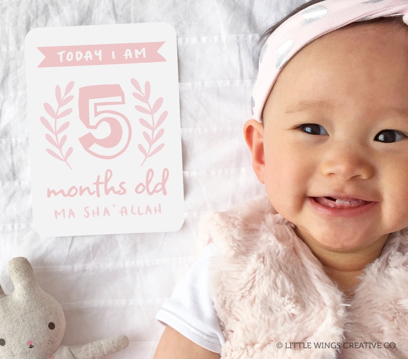 May include: A pink and white baby milestone card with the text "TODAY I AM 5 months old MA SHA' ALLAH". A baby girl is smiling and wearing a pink headband.