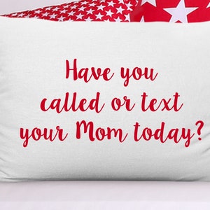 May include: White pillow with red star patterned fabric on the sides. The pillow has red text that reads "Have you called or text your Mom today?"