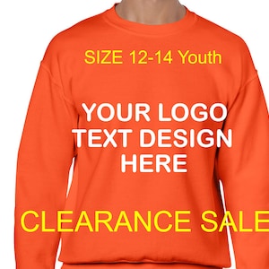 May include: Orange sweatshirt with the text "SIZE 12-14 Youth" and "YOUR LOGO TEXT DESIGN HERE" in white. The text "CLEARANCE SALE" is in yellow.