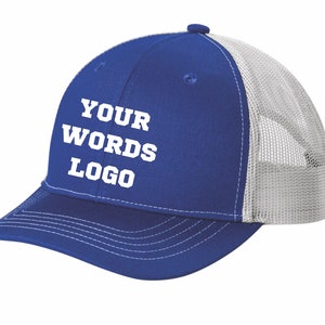 May include: A royal blue baseball cap with a white mesh back and a white button on top. The front panel features the white text "YOUR WORDS LOGO" in a bold, block-style font. The cap has a curved brim with white stitching detail.