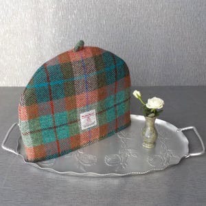 Funda para tetera de tela escocesa Harris Tweed en color rojo ladrillo y verde turquesa.