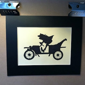 Könnte beinhalten: Eine schwarze Silhouette einer Person, die ein Oldtimer-Auto fährt. Die Person trägt einen Hut und einen Mantel und sitzt am Steuer. Das Auto hat ein großes, rundes Lenkrad und eine lange, schmale Karosserie. Die Silhouette ist vor einem weißen Hintergrund platziert.