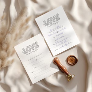Può includere: Due biglietti d'invito a nozze con la parola "LOVE" in un design a labirinto. Gli inviti sono su uno sfondo color crema con dettagli scritti a mano. Sono presenti anche un timbro di ceralacca con manico in legno e un sigillo di cera con un motivo a rosa.