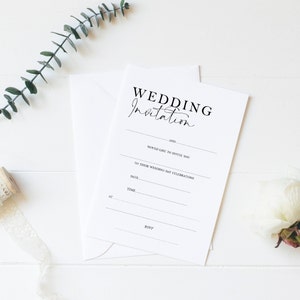 Può includere: Un biglietto di invito di nozze vuoto con il testo "WEDDING Invitation" in alto. Il biglietto ha righe per i nomi della coppia, la data, l'ora e le informazioni RSVP.