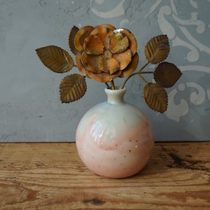 K&ouml;nnte beinhalten: Eine Keramikvase mit einem rosa-wei&szlig;en Ombre-Glaze und einer metallischen goldenen Rose mit Bl&auml;ttern.