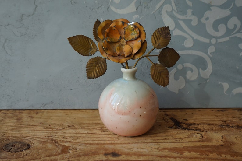 K&ouml;nnte beinhalten: Eine Keramikvase mit einem rosa-wei&szlig;en Ombre-Glaze und einer metallischen goldenen Rose mit Bl&auml;ttern.