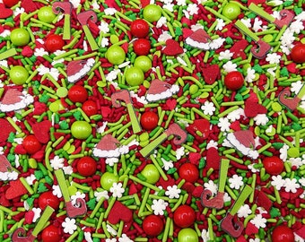 Op de afbeelding: Een feestelijke mix van eetbare strooisels met rode en groene staafjes, kleine witte bloemetjes, rode hartjes, glanzende rode en limoengroene suikerballetjes en platte suikervormpjes in de vorm van kerstmutsen en elfenschoenen.