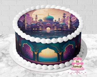 May include: A round cake featuring an edible image of a palace with blue domes and minarets at sunset, reflected in water. The sides display an arched architectural pattern in shades of teal and purple. White frosting borders the top and bottom edges.