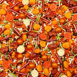 May include: A variety of fall-themed sprinkles in orange, brown, green, and white. The sprinkles include pumpkins, leaves, and other fall shapes.