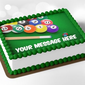 May include: A rectangular cake decorated with a green frosting that resembles a pool table. The cake features colorful billiard balls, a cue stick, and the text "YOUR MESSAGE HERE" in white. The edges are trimmed with green frosting.