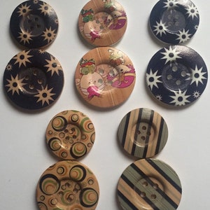 May include: Assortment of 10 wooden buttons with various designs. The buttons feature a variety of patterns, including stars, stripes, circles, and cartoon animals. The buttons are all approximately 2.5 cm in diameter.