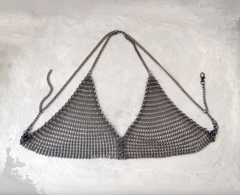 May include: A silver chainmail top with a triangular shape and adjustable straps.