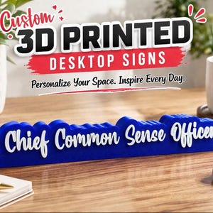 May include: A blue 3D printed desktop sign with the text "Chief Common Sense Officer" in white. The sign is on a wooden surface, with the words "Custom 3D Printed Desktop Signs" above it.