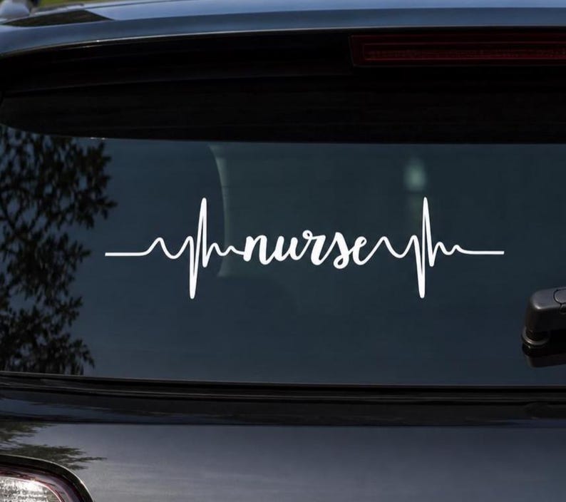 May include: White vinyl decal of a heartbeat line with the word "nurse" in cursive script. The decal is applied to the rear window of a black vehicle. The design is a symbol of the nursing profession.