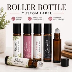 May include: Five amber glass roller bottles with black caps and custom labels. Four bottles stand upright with labels reading Breathe, Calm, Focus, and Lavender. One bottle lies horizontally labeled Relax. Each label indicates 10 ml capacity.