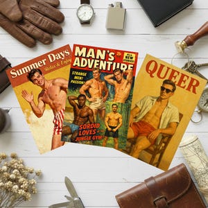 May include: Three vintage-style comic book covers with illustrations of men. The covers feature text like "Summer Days," "Man's Adventure," and "Queer." Surrounding the comics are leather gloves, a watch, a lighter, and other accessories.