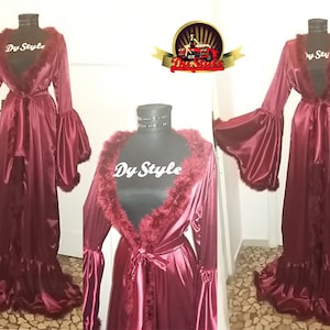 May include: A long, burgundy satin robe with a faux fur collar and cuffs. The robe has a tie belt and a ruffled hem.