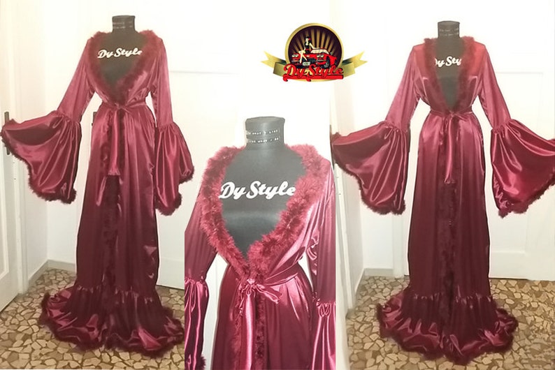 May include: A long, burgundy satin robe with a faux fur collar and cuffs. The robe has a tie belt and a ruffled hem.