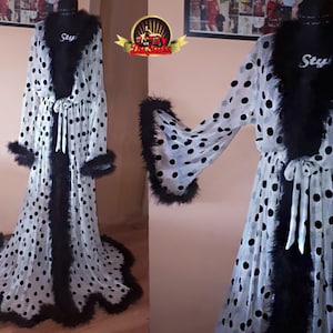May include: White sheer robe with black polka dots and black feather trim. The robe has a tie at the waist and long sleeves.