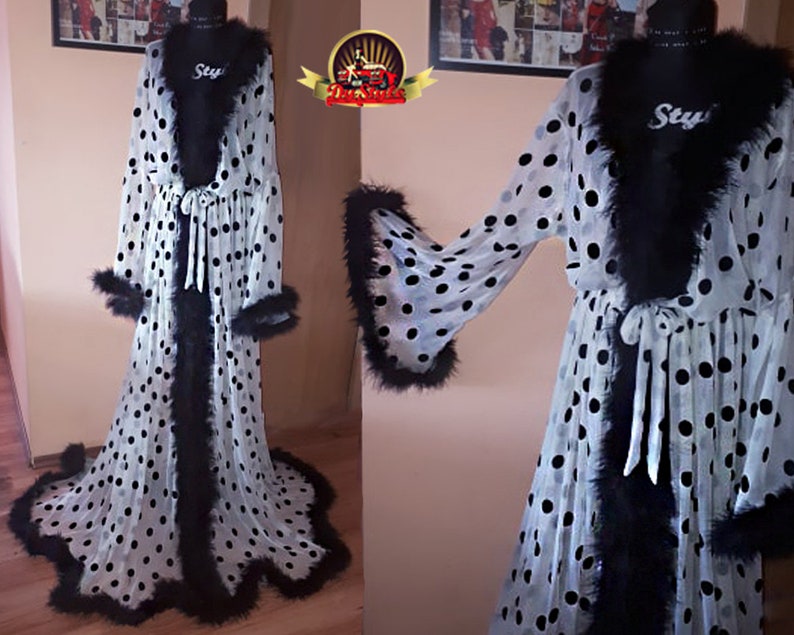 May include: White sheer robe with black polka dots and black feather trim. The robe has a tie at the waist and long sleeves.
