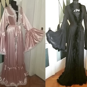 May include: Two long robes with a fluffy trim. One robe is pink satin and the other is black mesh.