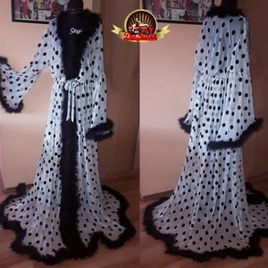 May include: White sheer robe with black polka dots and black feather trim. The robe has a long, flowing silhouette and a tie at the waist.