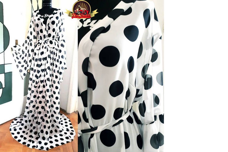 May include: A white sheer robe with black polka dots and a tie belt. The robe has long sleeves and a flowing skirt.