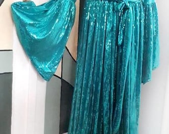 Op de afbeelding: Een lange turquoise sequinedoek met een strikceintuur en lange wijde mouwen.