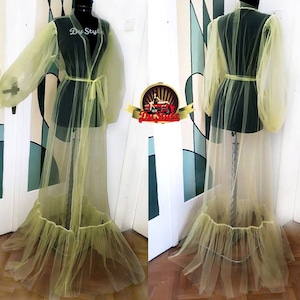 Puede incluir: Una larga bata de tul amarillo transparente con mangas abullonadas y un dobladillo con volantes. La bata se ata a la cintura con una cinta a juego.