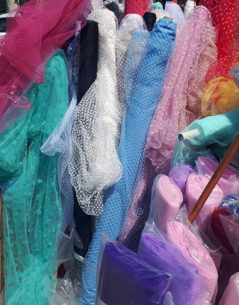 May include: Assortment of colorful tulle fabric rolls with polka dot patterns in various colors, including pink, blue, green, white, and purple.