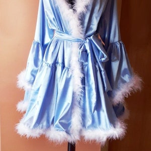 May include: A light blue satin robe with white feather trim. The robe has a tie belt and long sleeves.