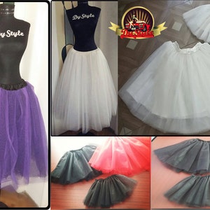 May include: A collection of tulle skirts in various colors, including purple, white, black, and red. The skirts are made of soft, flowing tulle and have a gathered waistband. The skirts are perfect for adding volume and a touch of whimsy to any outfit.