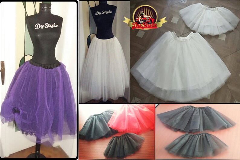 May include: A collection of tulle skirts in various colors, including purple, white, black, and red. The skirts are made of soft, flowing tulle and have a gathered waistband. The skirts are perfect for adding volume and a touch of whimsy to any outfit.