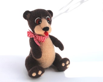 Teddy bear sitting in dark brown with bow