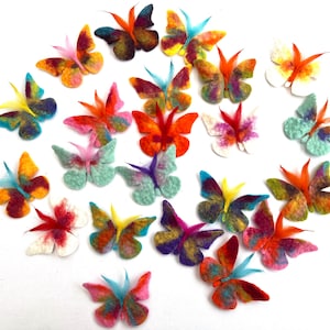 Può includere: Una collezione di 20 farfalle di feltro colorate con vari motivi e design. Le farfalle sono disposte in cerchio su uno sfondo bianco.