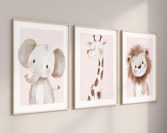 May include: Three framed wall art prints featuring watercolor-style illustrations of a baby elephant, a giraffe, and a lion. Each animal is depicted with soft features against a pale pink background, enclosed in light-colored wooden frames.
