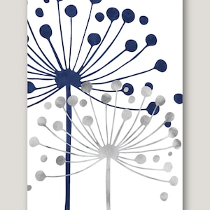 Puede incluir: Una pintura de acuarela de dos flores estilizadas con acentos azul marino y plata sobre un fondo blanco.