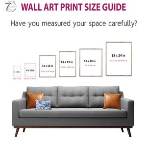 a couch with a pillow on top of it next to a wall art print size