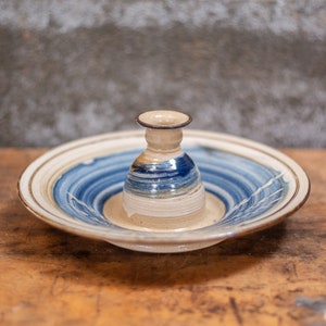 May include: A ceramic dish with a blue and white swirl design, featuring a smaller ceramic vase in the centre.