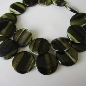 May include: A strand of round, green and black striped beads. The beads are made of a smooth, polished material and have a natural, organic look.