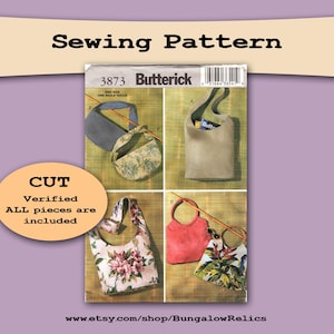 May include: A vintage Butterick sewing pattern showing four different bag designs. The pattern includes instructions for a tote bag, a floral print bag, a red handbag, and a patterned shoulder bag. The text on the pattern reads "Sewing Pattern" and "CUT. Verified ALL pieces are included."