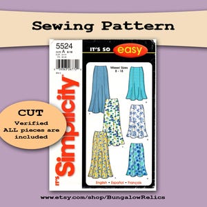 May include: A Simplicity sewing pattern for Misses' sizes 8-18, featuring skirt designs. The pattern includes the text "Sewing Pattern", "CUT", and "Verified ALL pieces are included". The pattern is on a purple background.