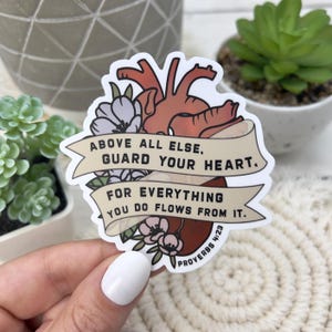 May include: A sticker with a heart illustration and the text "ABOVE ALL ELSE, GUARD YOUR HEART. FOR EVERYTHING YOU DO FLOWS FROM IT. PROVERBS 4:23".